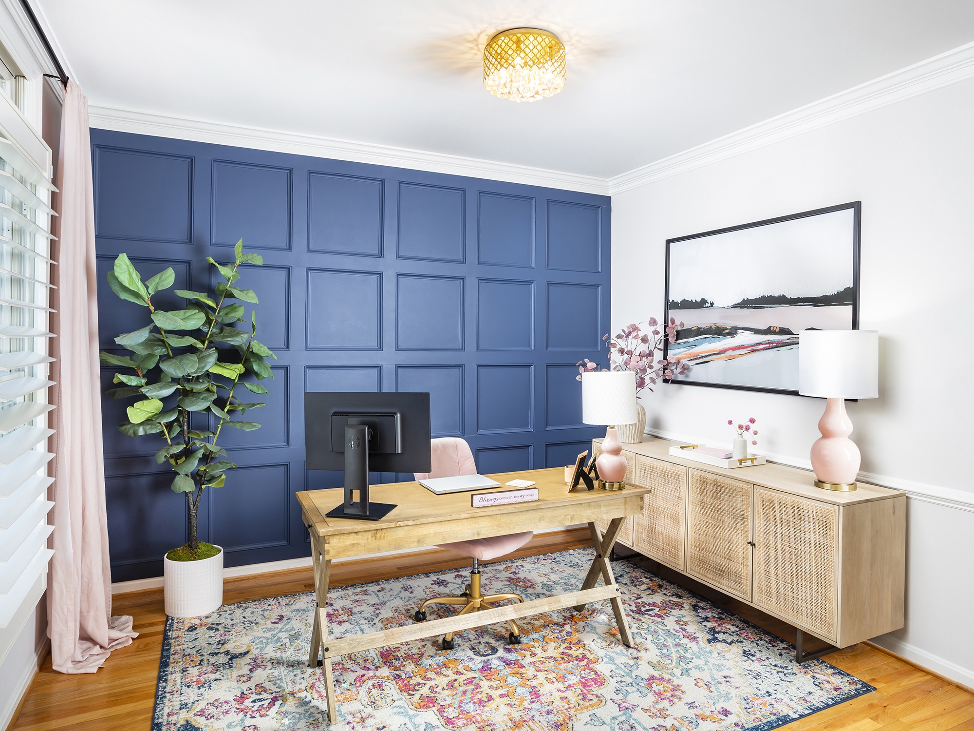 home office with blue statement wall and pink accents