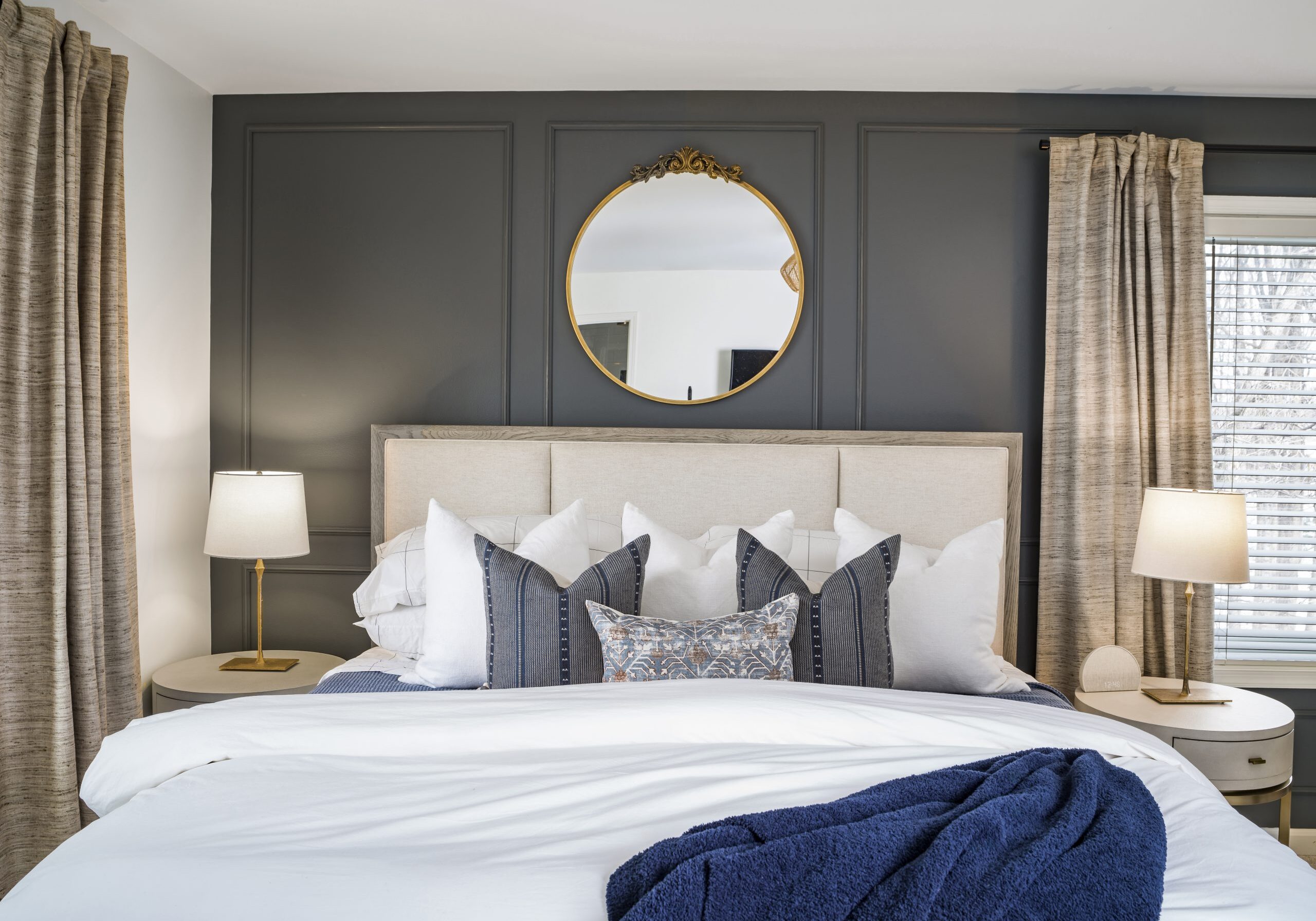 bedroom with neutral bed and accent wall with moulding